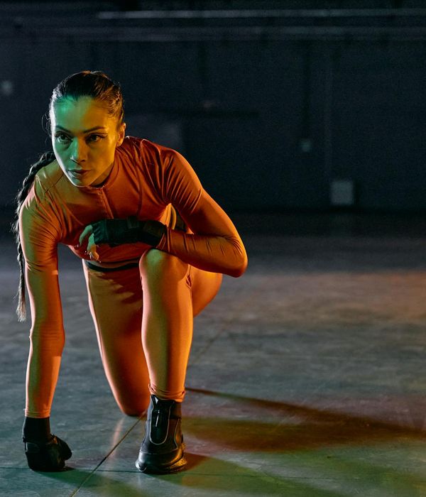 Woman performing a light cardio exercise in a modern studio.